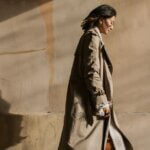 Peace of Mind Is the New Productivity Flex Person walking calmly along a sunlit wall, conveying confidence and ease.